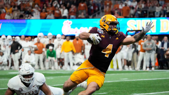 Arizona State running back Cam Skattebo (4) escapes a tackle by Texas defensive lineman Alfred Collins (95) during the fourth quarter in the Chick-fil-A Peach Bowl in Atlanta on Wednesday, Jan. 1, 2025.