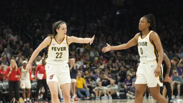 Jun 30, 2024; Phoenix, Ariz., U.S.; Indiana Fever guard Caitlin Clark (22) slaps hands with guard Kelsey Mitchell (0) during the third quarter against the Phoenix Mercury at Footprint Center. Mandatory Credit: Michael Chow-Arizona Republic Jun 30, 2024; Phoenix, Ariz., U.S.; Indiana Fever guard Caitlin Clark (22) slaps hands with guard Kelsey Mitchell (0) during the third quarter against the Phoenix Mercury at Footprint Center. Mandatory Credit: Michael Chow-Arizona Republic