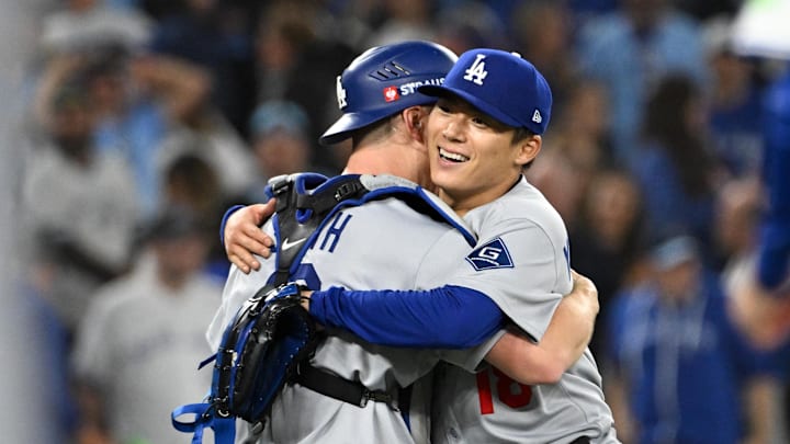 Oct 25, 2025; Toronto, Ontario, CAN; Los Angeles Dodgers pitcher Yoshinobu Yamamoto (18) and catcher Will Smith (16) celebrate after defeating the Toronto Blue Jays in game two of the 2025 MLB World Series at Rogers Centre. Mandatory Credit: Dan Hamilton-Imagn Images