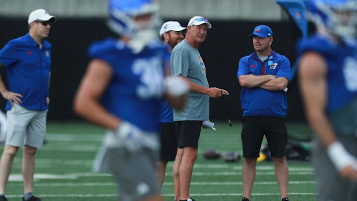 Kansas football coach Lance Leipold talks with staff during practice at the outdoor practice fields in Lawrence on July 24, 2025.