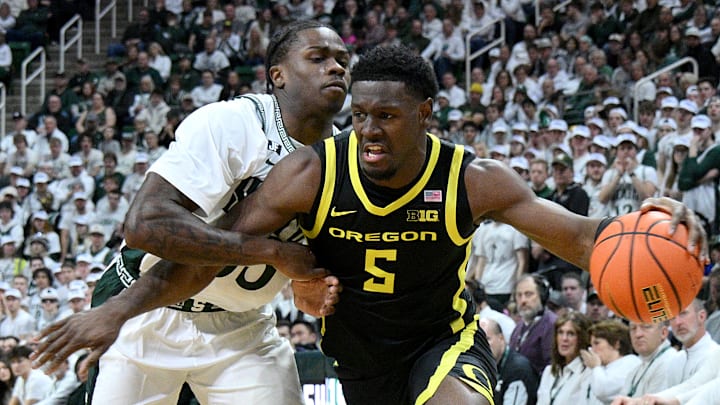 Feb 8, 2025; East Lansing, Michigan, USA;  Oregon Ducks guard TJ Bamba (5) drives against Michigan State Spartans forward Coen Carr (55) during the first half at Jack Breslin Student Events Center.