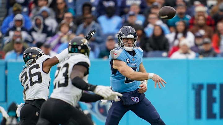 Tennessee Titans quarterback Will Levis (8) passes around Jacksonville Jaguars safety Antonio Johnson (26) during the third quarter at Nissan Stadium in Nashville, Tenn., Sunday, Dec. 8, 2024.