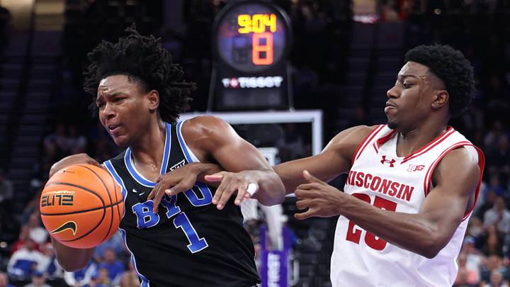 Nov 21, 2025; Salt Lake City, Utah, USA; BYU Cougars guard Robert Wright III (1) and Wisconsin Badgers guard John Blackwell (25) get tied up during the second half at Delta Center. Mandatory Credit: Rob Gray-Imagn Images