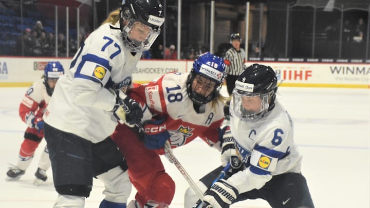 Finland's Susanna Tapani and Jenni Hiirikoski (6) work to keep the puck away from Czechia's Michaela Pejzova during the International Ice Hockey Federation Women's World Championship bronze medal game Sunday, April 14, 2024, at the Adirondack Bank Center in Utica, New York.