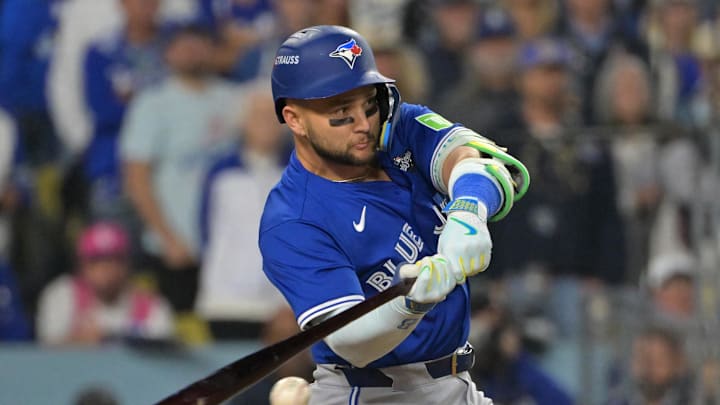 Oct 27, 2025; Los Angeles, California, USA; Toronto Blue Jays second baseman Bo Bichette (11) hits an RBI single against the Los Angeles Dodgers in the seventh inning during game three of the 2025 MLB World Series at Dodger Stadium. Mandatory Credit: Jayne Kamin-Oncea-Imagn Images