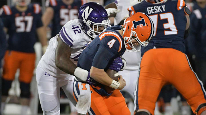 Nov 25, 2023; Champaign, Illinois, USA; Northwestern Wildcats defensive lineman Anto Saka (42) takes down Illinois Fighting Illini quarterback John Paddock (4) during the second half at Memorial Stadium. Mandatory Credit: Ron Johnson-Imagn Images