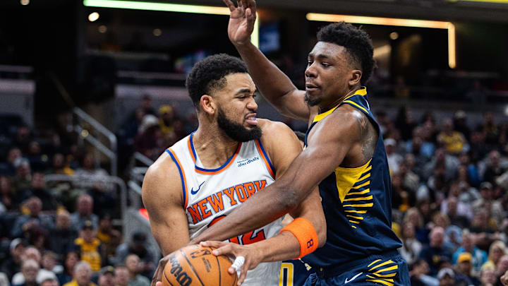 Feb 11, 2025; Indianapolis, Indiana, USA; New York Knicks center Karl-Anthony Towns (32) holds the ball while Indiana Pacers center Thomas Bryant (3) defends in the second half at Gainbridge Fieldhouse. Mandatory Credit: Trevor Ruszkowski-Imagn Images