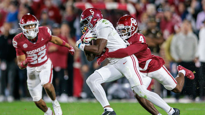 Nov 23, 2024; Norman, Oklahoma, USA; Alabama Crimson Tide wide receiver Germie Bernard (5) is tackled by Oklahoma Sooners defensive back Dez Malone (4) during the fourth quarter at Gaylord Family-Oklahoma Memorial Stadium. Mandatory Credit: William Purnell-Imagn Images