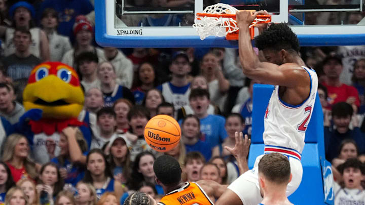 Feb 22, 2025; Lawrence, Kansas, USA; Kansas Jayhawks forward KJ Adams Jr. (24) dunks the ball as Oklahoma State Cowboys guard Brandon Newman (6) looks on during the first half at Allen Fieldhouse. Mandatory Credit: Denny Medley-Imagn Images