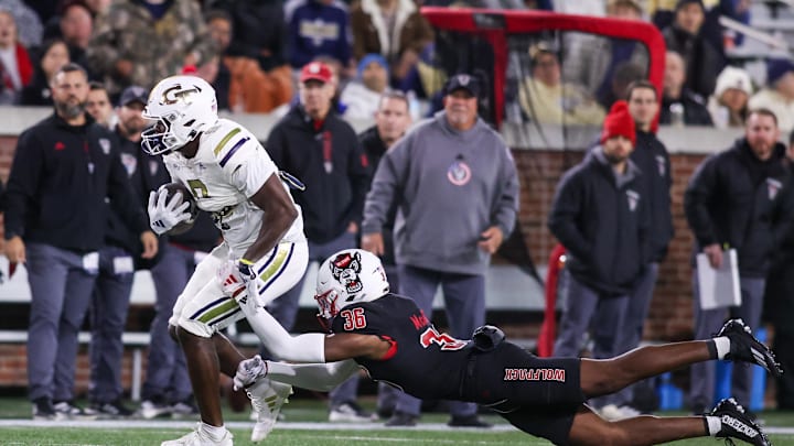 Nov 21, 2024; Atlanta, Georgia, USA; Georgia Tech Yellow Jackets wide receiver Avery Boyd (9) is tackles by North Carolina State Wolfpack linebacker Kelvon McBride (36) in the first quarter at Bobby Dodd Stadium at Hyundai Field. Mandatory Credit: Brett Davis-Imagn Images