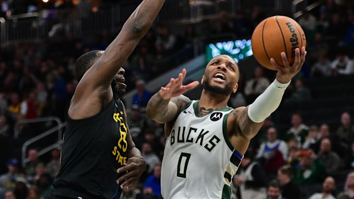 ; Milwaukee Bucks guard Damian Lillard (0) takes a shot against Golden State Warriors forward Draymond Green (23) in the third quarter at Fiserv Forum. Mandatory Credit: Benny Sieu-Imagn Images