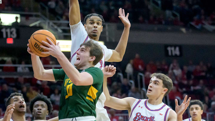 Vermont's TJ Long moves to the basket against Bradley's Darius Hannah, top, and Connor Hickman (10)