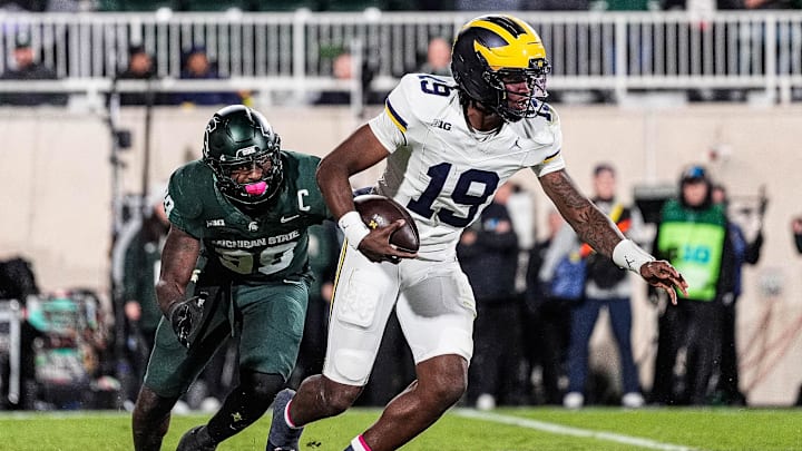 Michigan quarterback Bryce Underwood (19) runs against Michigan State defensive lineman Derrick Simmons (98) during the second half at Spartan Stadium in East Lansing on Saturday, October 25, 2025.