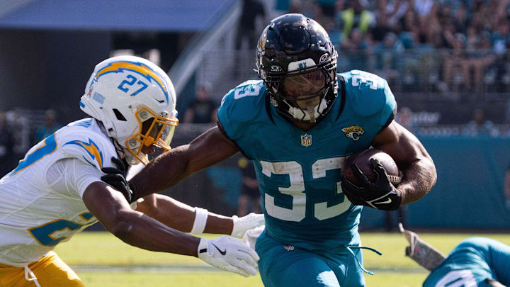 Jacksonville Jaguars running back Bhayshul Tuten (33) eludes a tackle in the second quarter as Los Angeles Chargers safety R.J. Mickens (27) tries to tackle him in an NFL football game at EverBank Stadium, Sunday, November 16, 2025, in Jacksonville, Fla. [Doug Engle/Florida Times-Union]