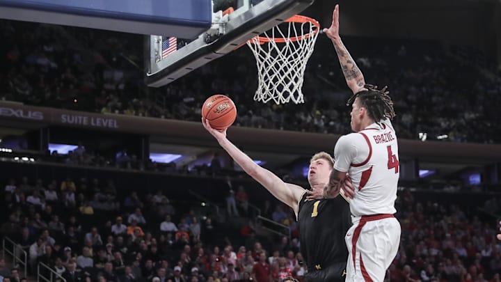 Dec 10, 2024; New York, New York, USA;  Michigan Wolverines center Danny Wolf (1) drives past Arkansas Razorbacks forward Trevon Brazile (4) in the second half at Madison Square Garden. Mandatory Credit: Wendell Cruz-Imagn Images