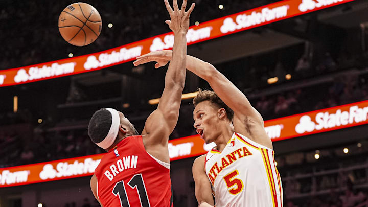 Jan 25, 2025; Atlanta, Georgia, USA; Atlanta Hawks guard Dyson Daniels (5) passes over Toronto Raptors forward Bruce Brown (11) during the first half at State Farm Arena. Mandatory Credit: Dale Zanine-Imagn Images