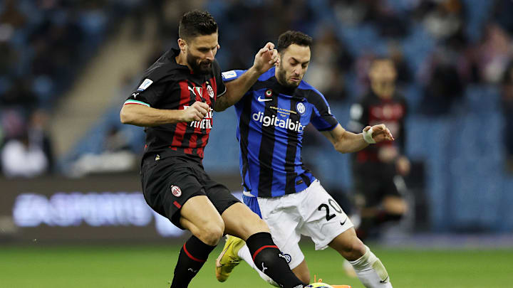 Olivier Giroud y Hakan Calhanoglu disputan un balón.