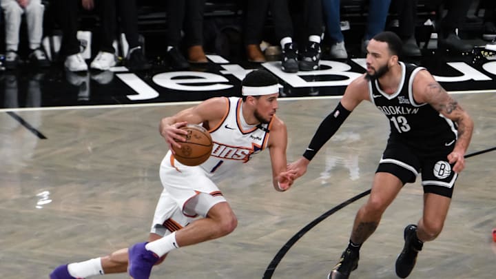 Jan 22, 2025; Brooklyn, New York, USA; Phoenix Suns guard Devin Booker (1) drives to the basket while being defended by Brooklyn Nets guard Tyrese Martin (13) during the second half at Barclays Center. Mandatory Credit: John Jones-Imagn Images