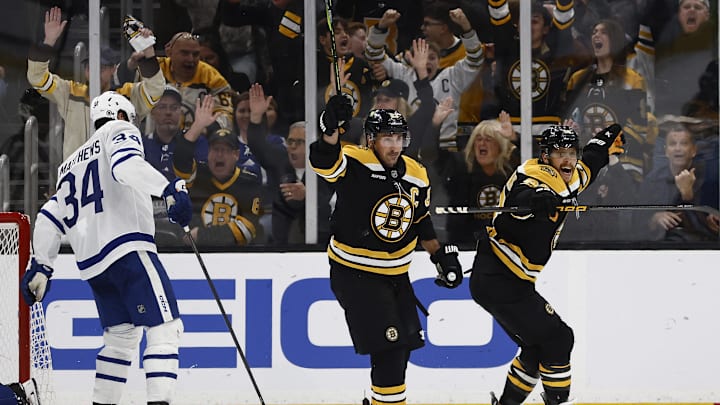 Oct 26, 2024; Boston, Massachusetts, USA; Boston Bruins right wing David Pastrnak (88) (right) and left wing Brad Marchand (63) celebrate the Bruins game winning overtime goal as Toronto Maple Leafs center Auston Matthews (34) skates away during overtime at TD Garden. Mandatory Credit: Winslow Townson-Imagn Images