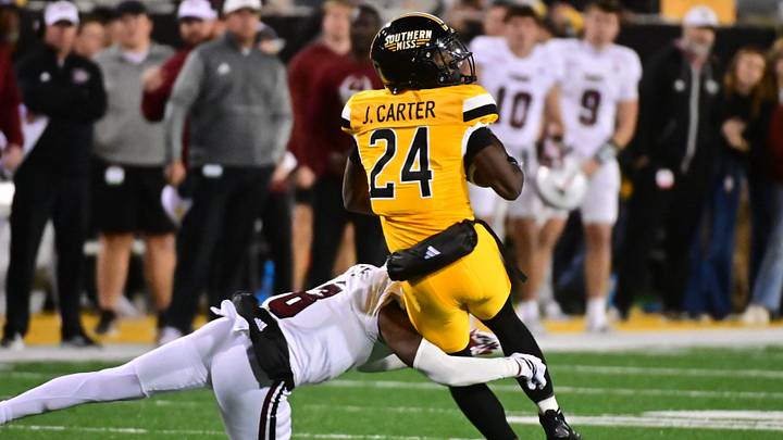 Southern Miss Golden Eagles wide receiver Jalen Carter (24) is tackled by Troy Trojans cornerback Jaquez White (8) during a college football game between Southern Miss and Troy at M.M. Roberts Stadium in Hattiesburg, Miss., on Saturday, Nov. 29, 2025. Troy defeated Southern Miss 28-18.