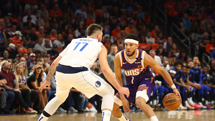 Oct 26, 2024; Phoenix, Arizona, USA; Phoenix Suns guard Devin Booker (1) against Dallas Mavericks guard Luka Doncic (77) in the first half of the home opener at Footprint Center. Mandatory Credit: Mark J. Rebilas-Imagn Images