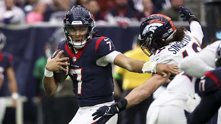 Dec 3, 2023; Houston, Texas, USA; Houston Texans quarterback C.J. Stroud (7) attempts to escape the grasp of Denver Broncos linebacker Alex Singleton (49) during the fourth quarter at NRG Stadium. Mandatory Credit: Troy Taormina-Imagn Images