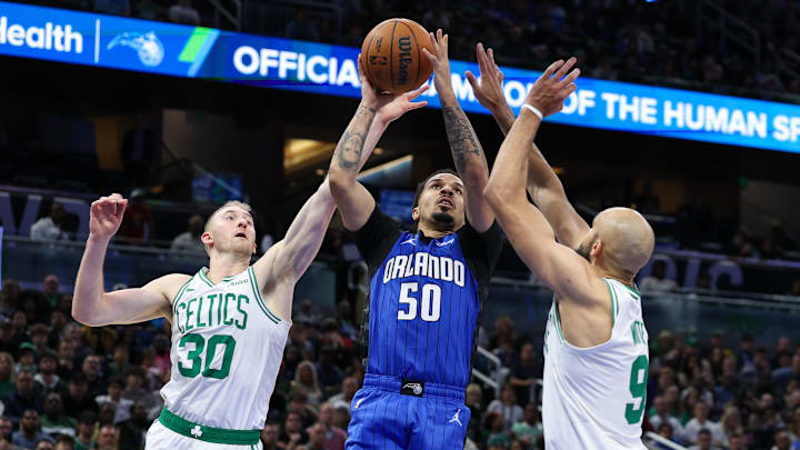 Dec 23, 2024; Orlando, Florida, USA; Orlando Magic guard Cole Anthony (50) shoots the ball  over Boston Celtics guard Derrick White (9) in the third quarter at Kia Center. Mandatory Credit: Nathan Ray Seebeck-Imagn Images