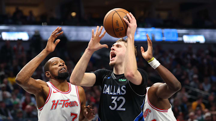 Jan 3, 2026; Dallas, Texas, USA; Dallas Mavericks forward Cooper Flagg (32) shoots as Houston Rockets forward Kevin Durant (7) and Houston Rockets center Clint Capela (30) defend during the second half at American Airlines Center. Mandatory Credit: Kevin Jairaj-Imagn Images