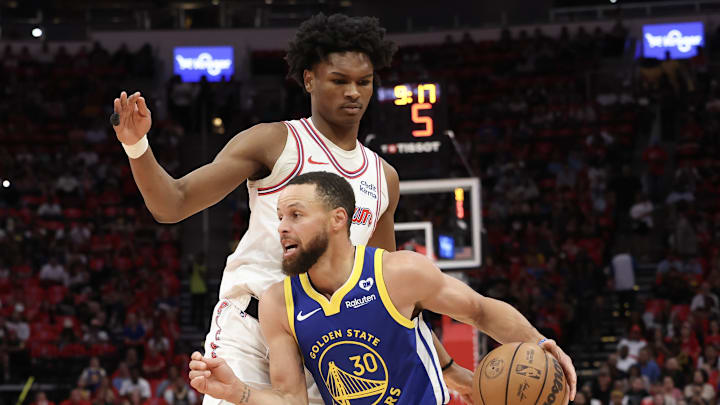 Golden State Warriors guard Stephen Curry dribbles against the Houston Rockets forward Amen Thompson.