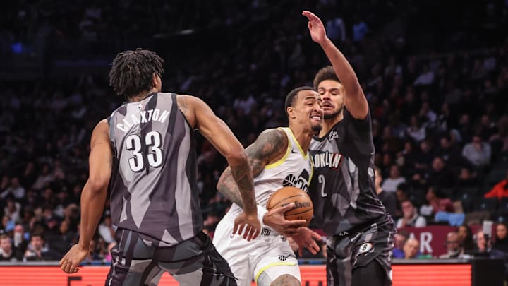 Dec 21, 2024; Brooklyn, New York, USA;  Utah Jazz forward John Collins (20) drives against Brooklyn Nets forward Cameron Johnson (2) and center Nic Claxton (33) in the third quarter at Barclays Center. Mandatory Credit: Wendell Cruz-Imagn Images