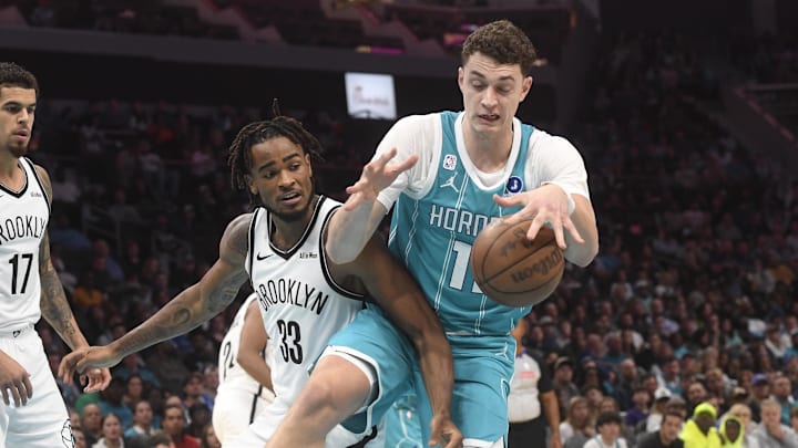 Oct 22, 2025; Charlotte, North Carolina, USA;  Charlotte Hornets center Ryan Kalkbrenner (11) and Brooklyn Nets forward Liam McNeeley (33) fight for a rebound during the second half at the Spectrum Center. Mandatory Credit: Sam Sharpe-Imagn Images