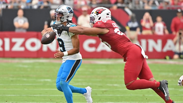 Sep 14, 2025; Glendale, Arizona, USA;  Arizona Cardinals linebacker Baron Browning (5) reaches for Carolina Panthers quarterback Bryce Young (9) during the first quarter at State Farm Stadium. Mandatory Credit: Matt Kartozian-Imagn Images