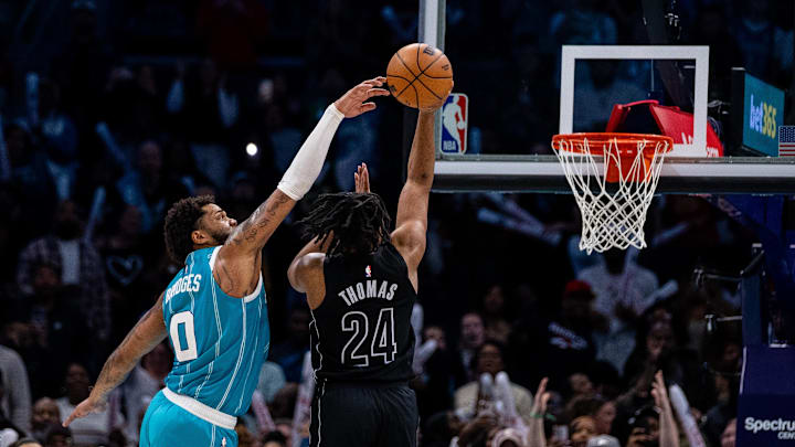 Mar 8, 2025; Charlotte, North Carolina, USA; Charlotte Hornets forward Miles Bridges (0) blocks a shot from Brooklyn Nets guard Cam Thomas (24) during the fourth quarter at Spectrum Center. Mandatory Credit: Scott Kinser-Imagn Images