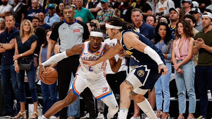 May 11, 2025; Denver, Colorado, USA; Oklahoma City Thunder guard Shai Gilgeous-Alexander (2) controls the ball as Denver Nuggets forward Aaron Gordon (32) guards in the first quarter during game four of the second round of the 2025 NBA Playoffs at Ball Arena. Mandatory Credit: Isaiah J. Downing-Imagn Images