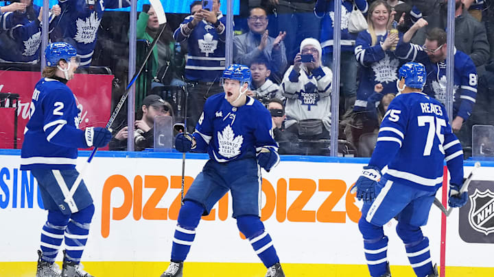 Dec 31, 2024; Toronto, Ontario, CAN; Toronto Maple Leafs center Steven Lorentz (18) scores a goal and celebrates with defenseman Simon Benoit (2) against the New York Islanders during the second period at the Scotiabank Arena. Mandatory Credit: Nick Turchiaro-Imagn Images