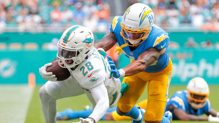 Oct 12, 2025; Miami Gardens, Florida, USA; Miami Dolphins running back De'Von Achane (28) carries the football against Los Angeles Chargers cornerback Benjamin St-Juste (24) during the second quarter at Hard Rock Stadium. Mandatory Credit: Sam Navarro-Imagn Images