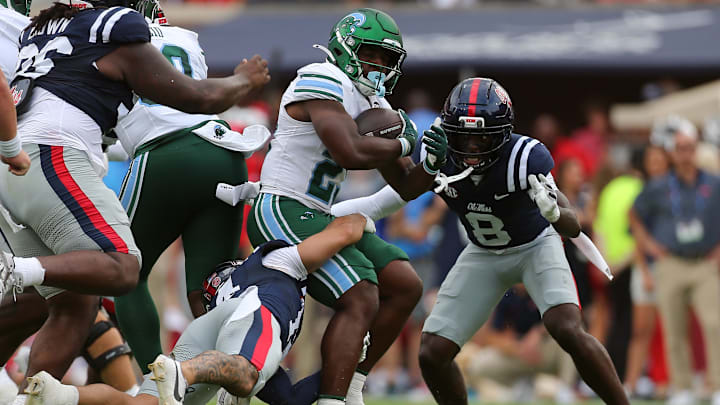 Sep 20, 2025; Oxford, Mississippi, USA; Tulane Green Wave running back Javin Gordon (23) runs the ball as Mississippi Rebels defensive backs Kapena Gushiken (14) and Antonio Kite (8) make the tackle during the second quarter at Vaught-Hemingway Stadium. Mandatory Credit: Petre Thomas-Imagn Images