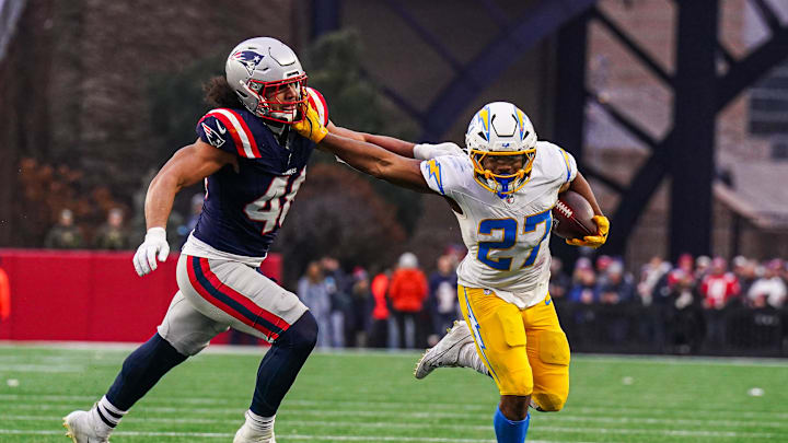 Dec 28, 2024; Foxborough, Massachusetts, USA; Los Angeles Chargers running back J.K. Dobbins (27) runs the ball against New England Patriots linebacker Jahlani Tavai (48) in the second half at Gillette Stadium. Mandatory Credit: David Butler II-Imagn Images