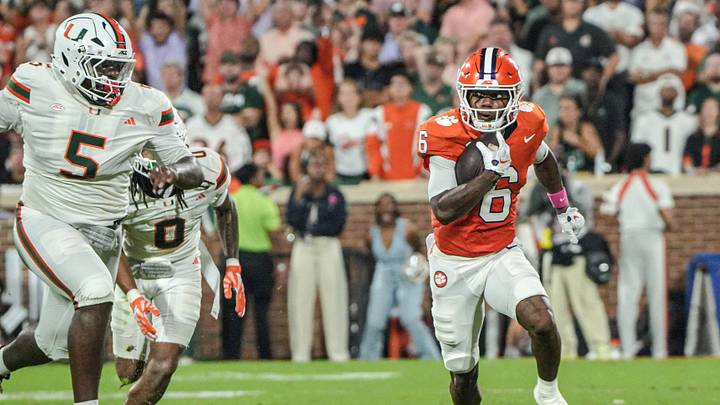 Clemson receiver Tyler Brown (6) runs by Miami Hurricanes defensive lineman Justin Scott (5) during the first quarter at Memorial Stadium Saturday, October 3, 2026.