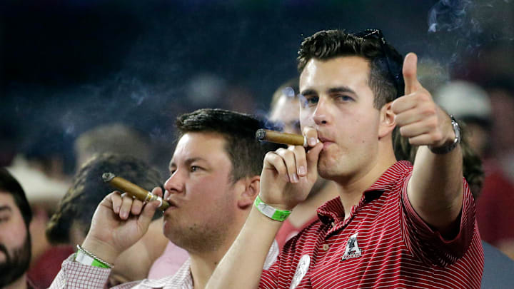 Oct 23, 2021; Tuscaloosa, Alabama, USA; Alabama Crimson Tide fans celebrate with the traditional cigar during the second half of a victory over the Tennessee Volunteers at Bryant-Denny Stadium. Mandatory Credit: Butch Dill-Imagn Images