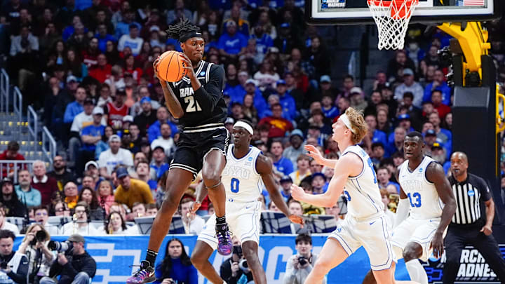 Mar 20, 2025; Denver, CO, USA; VCU Rams forward Christian Fermin (21) has the ball against Brigham Young Cougars forward Mawot Mag (0) and forward Richie Saunders (15) during the first half in the first round of the NCAA Tournament at Ball Arena. Mandatory Credit: Ron Chenoy-Imagn Images