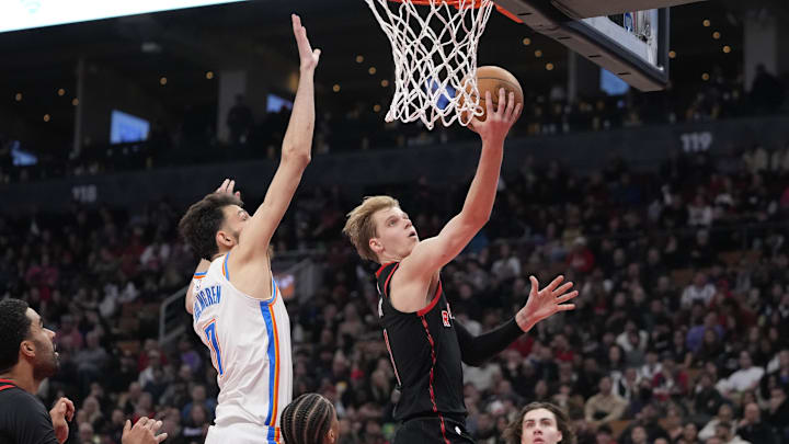 Mar 22, 2024; Toronto, Ontario, CAN; Toronto Raptors guard Gradey Dick (1) goes up to make a basket against Oklahoma City Thunder forward Chet Holmgren (7) during the second half at Scotiabank Arena. Mandatory Credit: John E. Sokolowski-Imagn Images