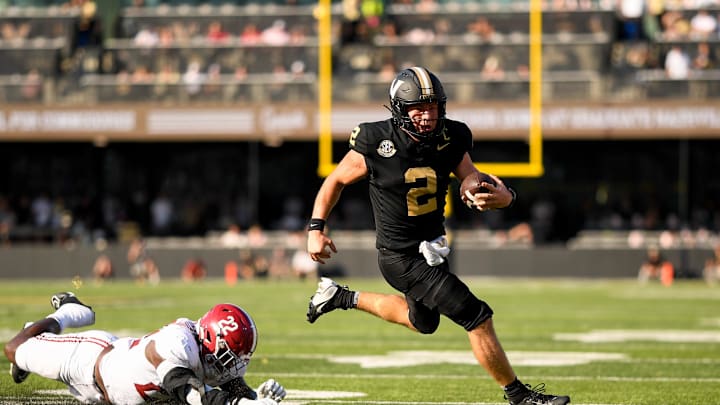 Oct 5, 2024; Nashville, Tennessee, USA;  Vanderbilt Commodores quarterback Diego Pavia (2) breaks the tackle of Alabama Crimson Tide defensive lineman LT Overton (22) during the first half at FirstBank Stadium. Mandatory Credit: Steve Roberts-Imagn Images