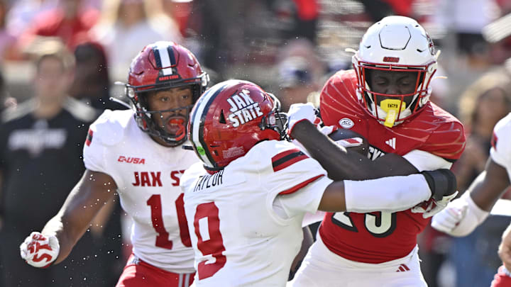 Sep 7, 2024; Louisville, Kentucky, USA;  Louisville Cardinals running back Isaac Brown (25) tries to break free from the tackle of Jacksonville State Gamecocks safety Pat Taylor (9) during the first half at L&N Federal Credit Union Stadium. Mandatory Credit: Jamie Rhodes-Imagn Images