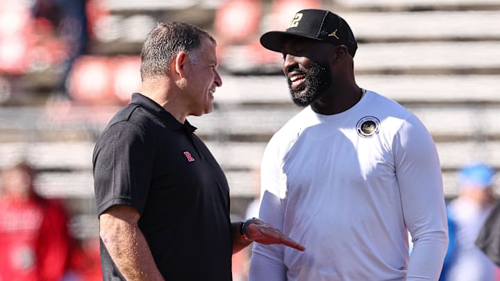 Oct 19, 2024; Piscataway, New Jersey, USA; Rutgers Scarlet Knights head coach Greg Schiano, left, talks with UCLA Bruins head coach DeShaun Foster before their Big Ten conference game at SHI Stadium. Mandatory Credit: Vincent Carchietta-Imagn Images