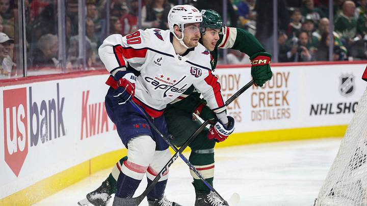 Mar 27, 2025; Saint Paul, Minnesota, USA; Washington Capitals left wing Pierre-Luc Dubois (80) and Minnesota Wild defenseman Brock Faber (7) compete for the puck during the first period at Xcel Energy Center. Mandatory Credit: Matt Krohn-Imagn Images