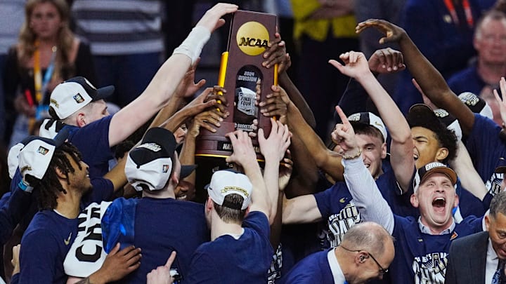 Connecticut Huskies head coach Dan Hurley and players celebrate with the trophy after defeating the Purdue Boilermakers in the national championship game of the Final Four of the 2024 NCAA Tournament at State Farm Stadium in Glendale on April 8, 2024.