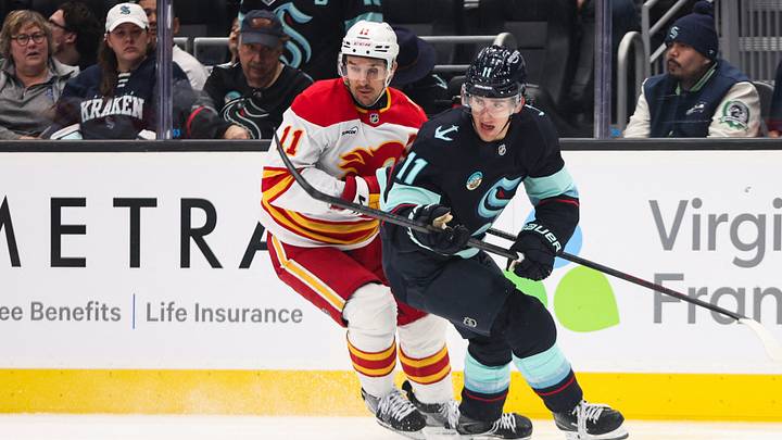 Oct 4, 2026; Seattle, Washington, USA; Seattle Kraken right wing Mackie Samoskevich (11) and Calgary Flames center Mikael Backlund (11) battle for the puck in the second period at Climate Pledge Arena. Mandatory Credit: Kevin Ng-Imagn Images