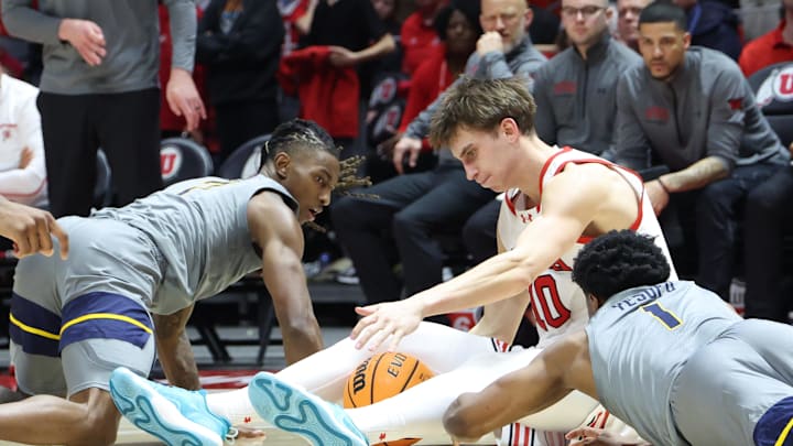 Mar 4, 2025; Salt Lake City, Utah, USA; Utah Utes forward Jake Wahlin (10) goes to the floor for a loose ball with West Virginia Mountaineers guard Javon Small (left) and guard Joseph Yesufu (1) during the second half at Jon M. Huntsman Center. Mandatory Credit: Rob Gray-Imagn Images