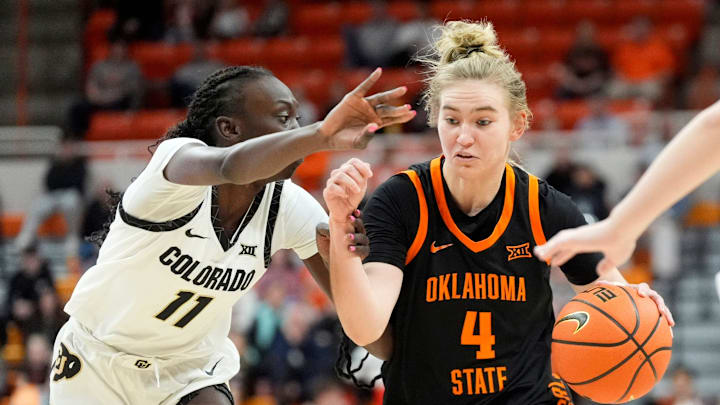 Oklahoma State guard Anna Gret Asi (4) drives to the basket as Colorado forward Nyamer Diew (11) defends during the college basketball game between the Oklahoma State University Cowgirls and the Colorado Buffaloes, Saturday, Feb., 22, 2025.